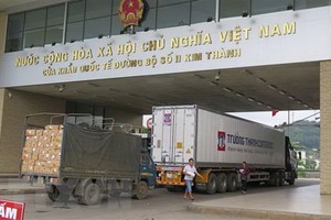 兩輛運載農產品的貨車經老街金城口岸通關運往中國。（圖源：越通社）