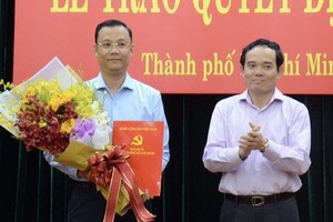 高山安同志（左）接領市委辦公廳副主任職務的《決定》。（圖源：B. Ngọc）