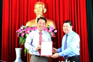 新任永隆省人委會主席呂光亮（左）接領人事委任《決定》。（圖源：VNN）