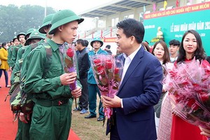 河內市人委會主席阮德鐘（前右）向新兵贈花慰勞。（圖源：雲英）