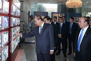 政府總理阮春福觀看電台的圖片展。（圖源：越通社）