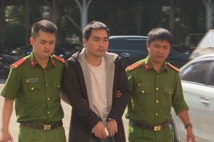 殺人犯罪嫌疑人龍清秀（中）被押送至派出所。（圖源：屈原）