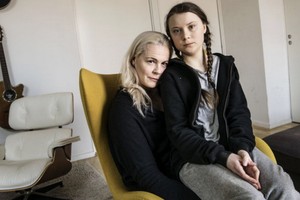 瑞典“環保少女”格蕾塔⋅桑伯格坐在母親懷裡。（圖源：Sputnik）