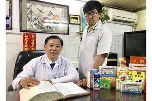 鍾世強醫師（左）與三子興榮探討醫術。