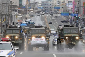 韓軍車2月29日在大邱街頭噴灑消毒劑。（圖源：AFP）