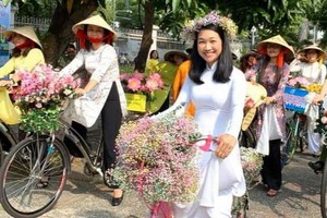 華人女企業家龐美玲參加穿長衫 騎自行車遊行活動。