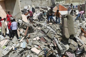 救援人員在居民樓倒塌事故現場救援。（圖源：AFP）