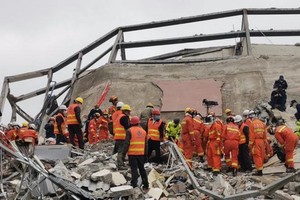 消防人員在廢墟上進行救援。（圖源：互聯網）