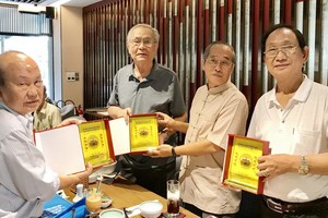 黃有義理事長（右二）向各書畫家贈送紀念章。