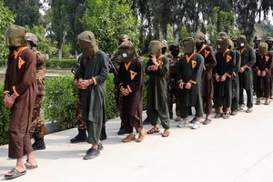 圖為被押解的塔利班囚犯。（圖源：路透社）