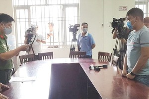 新富郡公安員向失實資訊散播者Ng.V.Đ （右）宣讀處罰《決定》。（圖源：PV）