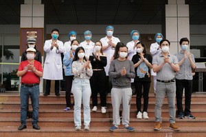 在中央熱帶病醫院收治的11 名新冠肺炎患者痊愈出院前與醫護人員合照。（圖源：玉成）