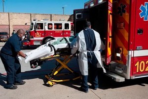 4月9日，美國維州，醫護人員將新冠肺炎患者送上救護車。（圖源：AFP）