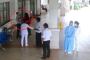 阮文雄（紅圈示）防疫期間陪妻子到大勒環美醫院看診，但進門時拒絕接受體溫測試，隨後還打罵保安員鬧成大事。（圖源：視頻截圖）