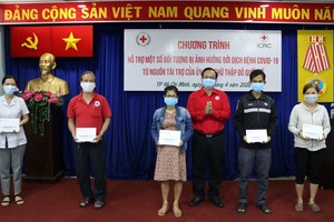 越南中央紅十字會副主席武清流向貧困者贈送補助金。