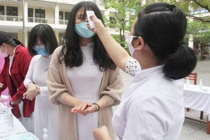 學生進校前都先要量體溫。（圖源：教育報）