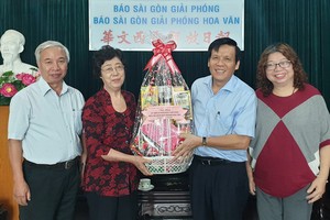 《西貢解放報》副總編輯、本報主編阮玉英(紅藍)與記者等親切接待代表團。