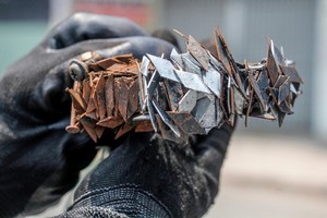 “釘賊剋星”阮文成採用自造的磁鐵盒在１號國道上吸到的一大堆菱形釘子。（圖源：周俊）