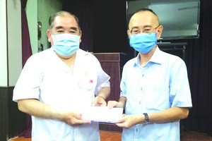 范興主任(右)轉贈本報讀者捐助的善款。