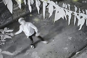 監控視頻錄下一名男青年向屋內方向潑灑蝦醬的畫面。（圖源：視頻截圖）