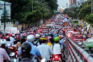 舊邑郡阮泰山高架橋附近路段下班高峰期車輛擁堵長達一公里，人車寸步難行。（圖源：周俊）