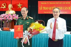 市委書記阮善仁向陳文南少將頒授《決定》並送鮮花祝賀。（圖源：市黨部新聞網）