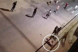 兩夥青年因發生爭執導致互毆，手持利器在一陣亂砍混戰中，一名青年（白圈示）不幸被砍斷手臂倒地，隨後獲送醫院搶救，但其後不治身亡。（圖源：視頻截圖）