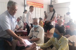 第十一郡社會工作團探望檳椥省巴知縣安德鄉並向當地民眾贈送現金禮物。（圖源：明英）