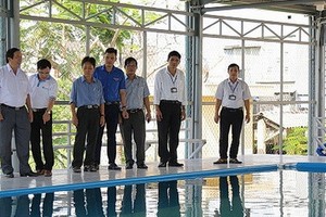 吉勝初中學校的老師們在觀察新建的游泳池。（圖源：VOV）