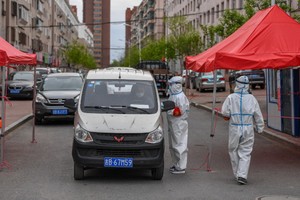 5月18日，在舒蘭市通機小區，工作人員為出入居民測溫登記。（圖源：新華社）