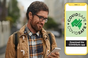 一名澳洲男士在查看手機上的病毒接觸者追蹤應用程序消息。（圖源：互聯網）