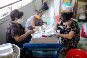 阮氏調（右）與姐妹們準備飯菜送給貧困者。