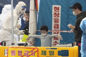 一名兒童在篩查站接受新冠病毒檢測。 （圖源：韓聯社）