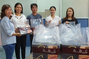 本報工會副主席陳月寶（左一）代表工會接收禮物和派發給有少兒子弟的工會會員。