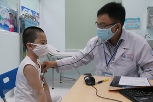 市第一兒童醫院醫生在給一名病童看診。（圖源：越通社）