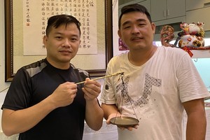 華人年輕企業家謝立輝（右）向陳列室捐贈藥材古秤。