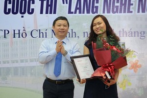 市人委會副主席楊英德向第一名得獎者頒發獎狀和祝賀鮮花。（圖源：黃潮）