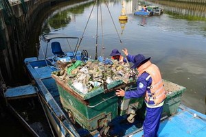 清潔員在饒祿-氏藝涌上打撈垃圾，確保湧渠暢通美觀。（圖源：田升）