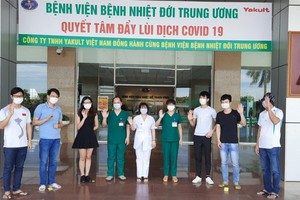 在中央熱帶病醫院收治的6名新冠肺炎患者痊愈出院前與醫護人員合照。（圖源：楊海）