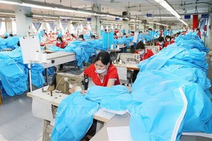 戰勝紡織成衣股份公司工人在縫製醫用防護服。（圖源：越通社）