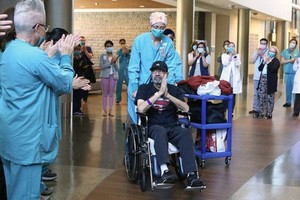 醫護人員列隊鼓掌歡送弗洛爾病愈出院。（圖源：Seattle Times）