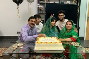 馬拉拉（中）父母與家人為她慶祝。