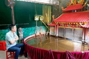 潘清廉藝人與其小型水上木偶戲院。