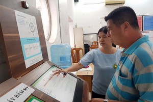 第一郡新定坊人委會幹部指引民眾通過 線上公共勞務辦手續。