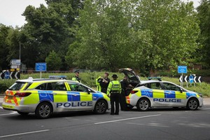 警察在持刀襲擊事發地外警戒。（圖源：新華社）