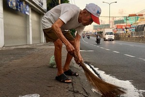 阮文謹老翁每天早起，把街道打掃乾凈。
