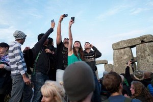 人們在巨石前高舉手機自拍。（圖源：互聯網）