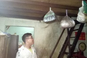 洪志強在漏水的屋子裡。