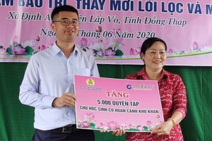 中國建行本市分行代表向同塔立武捐贈練習簿。