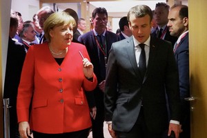 德國總理默克爾（左）與法國總統馬克龍交談。（圖源：新華社）